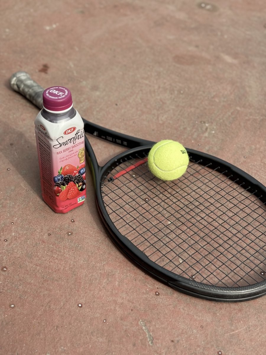 Mix Berry Korean smoothie beside a tennis racket and ball